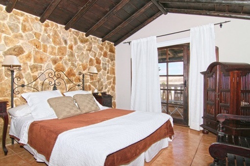 Bedroom with natural stone wall and wooden beams